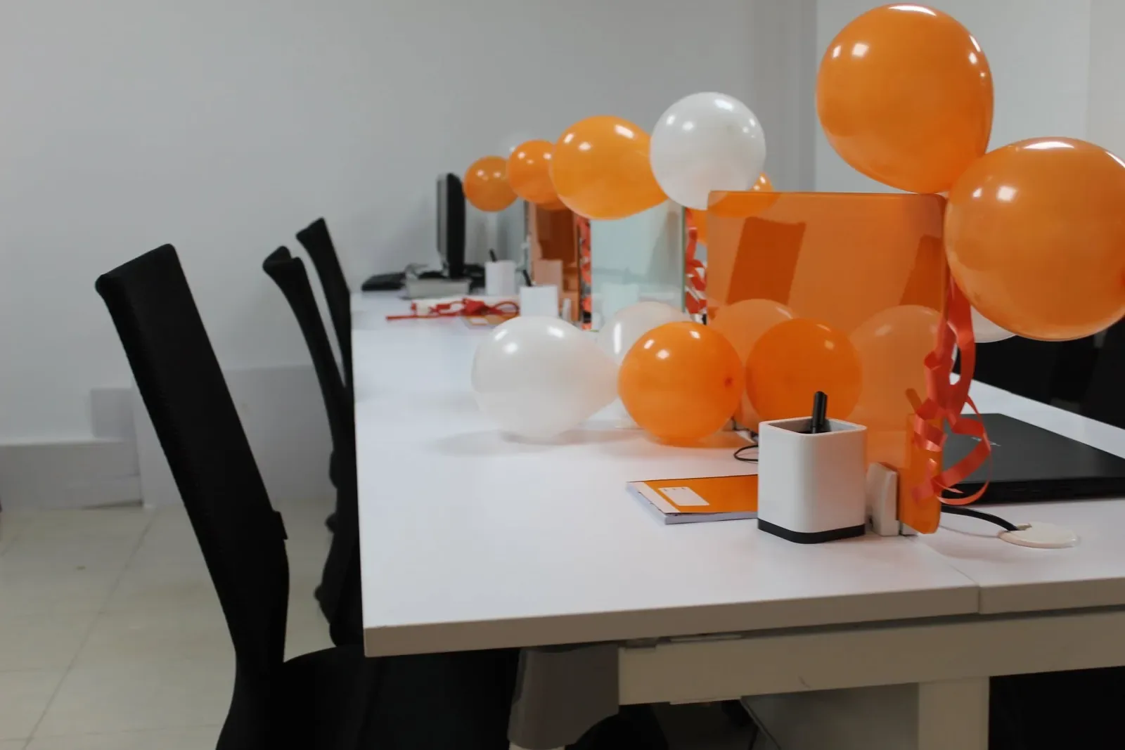 Desks decorated with orange and white balloons for the office opening