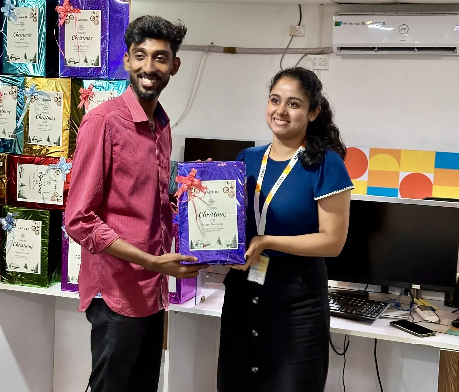 Two colleagues holding their Christmas gifts